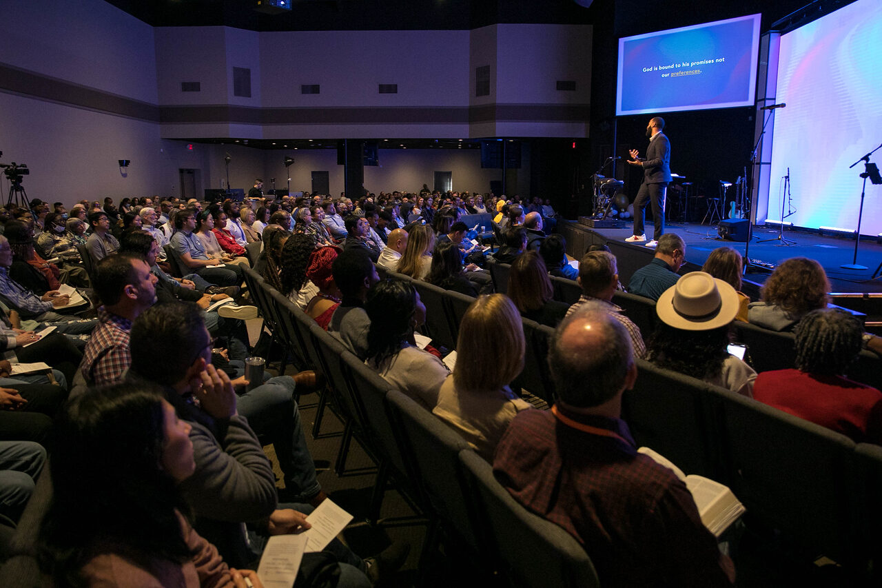 Xavier Maryland teaching from the stage to a full congregation